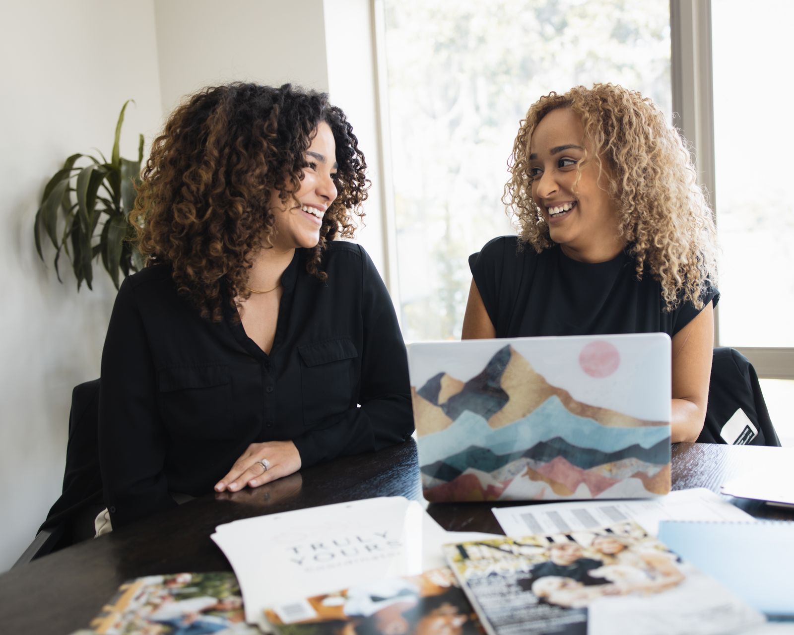 Two colleagues talking through a plan at a desk