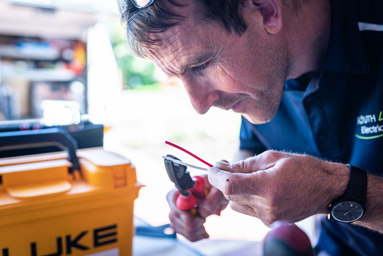Electrician working on wiring with hand tools