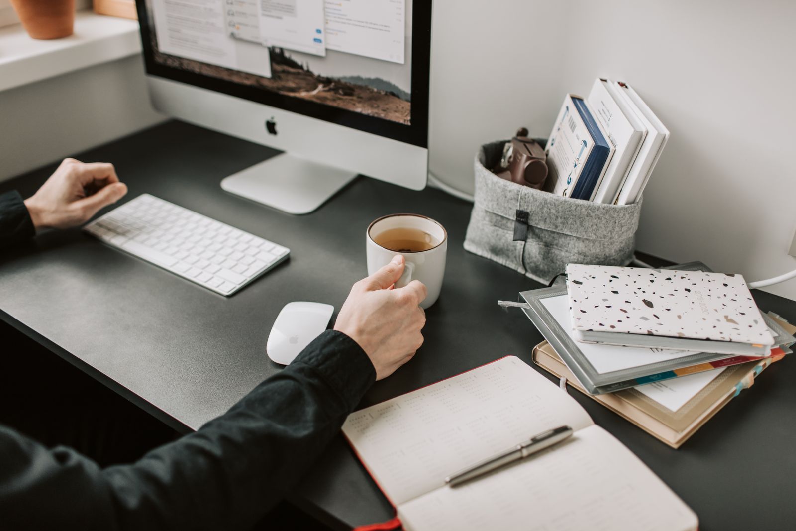 Team member with a coffee at a tidy workspace