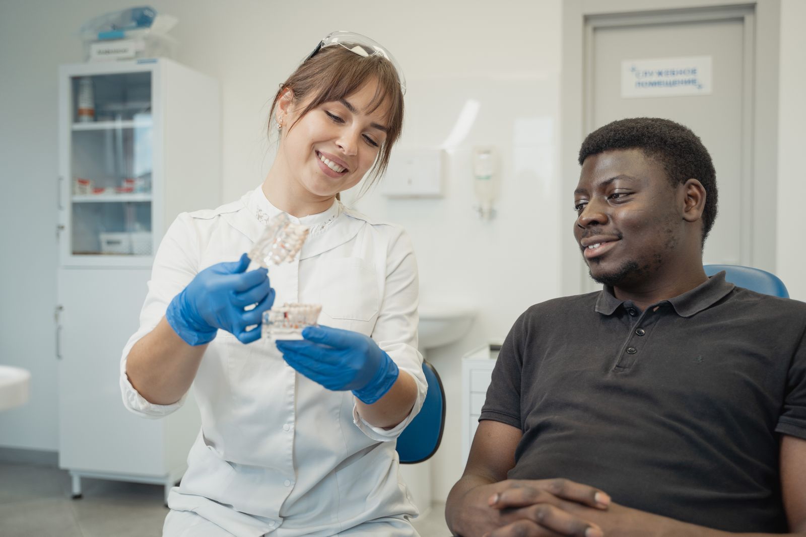 Dentist showing a dental model to a relaxed patient