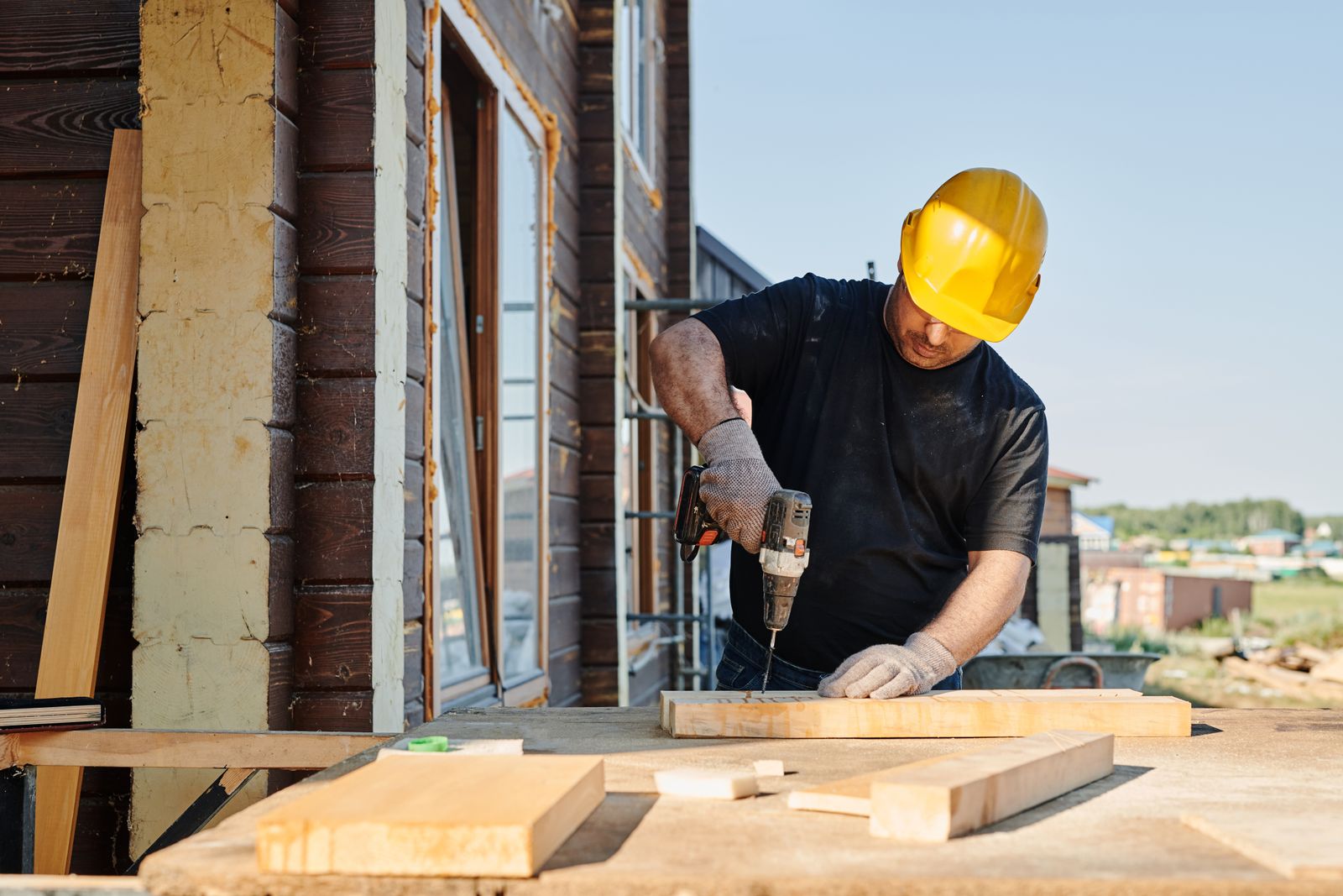 Builder using a power drill on site